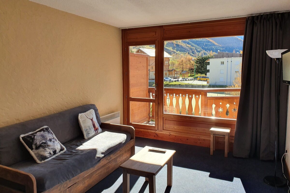 A living room with a couch and a pillow with a wolf on it