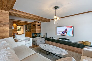 A living room with a flat screen tv showing a ski race