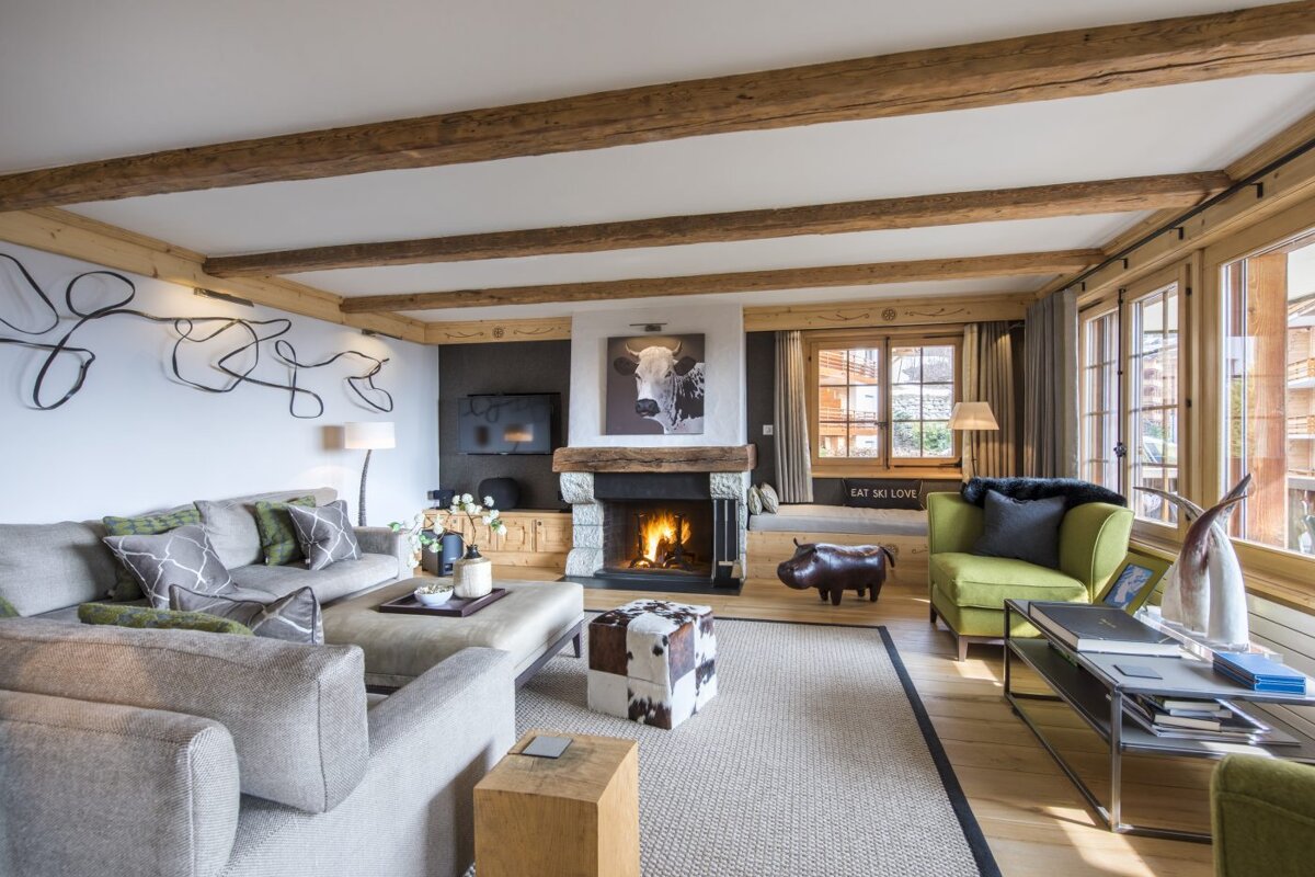 A living room with a fireplace and a painting of a cow on the wall