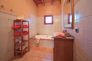 A bathroom with a tub a sink and a mirror