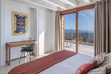 A cannes poster hangs above a bed in a bedroom