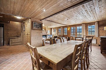 A dining room with a table and chairs and a painting on the wall