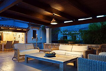 A patio with wicker furniture and a wooden table