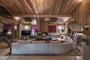 A living room with a curved couch and a fireplace