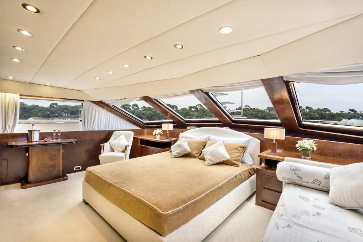 A bedroom on a boat with a bed and a chair