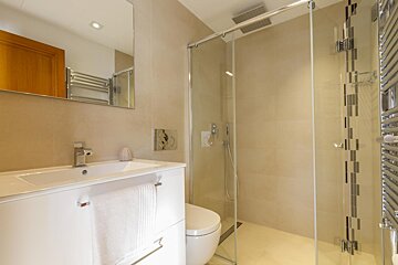 A bathroom with a toilet a sink and a shower