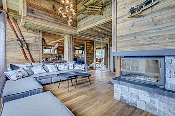 A living room with a sectional couch and a fireplace