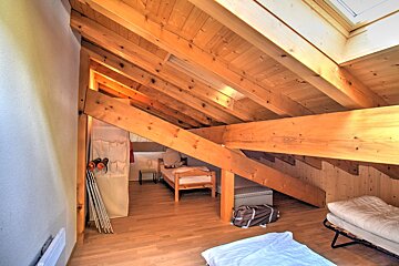 A bedroom with a wooden ceiling and stairs
