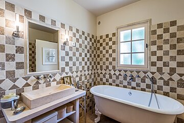 A bathroom with checkered tiles and a bathtub