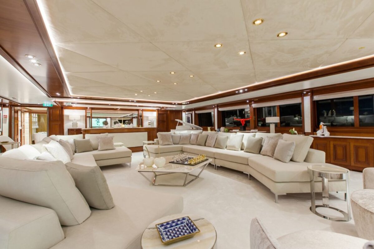 A living room with white furniture and a piano