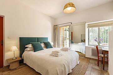A bedroom with a large bed and a large mirror
