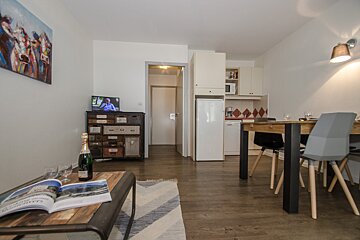 A bottle of champagne sits on a table in a living room