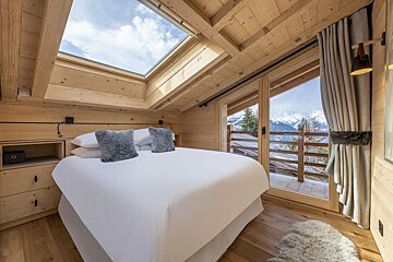A bedroom with a skylight above the bed
