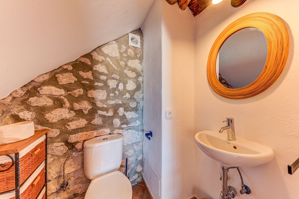 A bathroom with a toilet a sink and a mirror