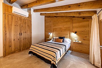 A bedroom with wooden walls and a bed with a striped blanket