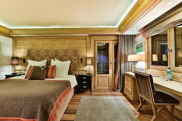 A bedroom with a large bed and a desk