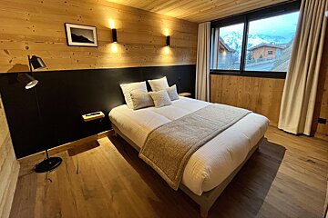 A bedroom with a large bed and a large window