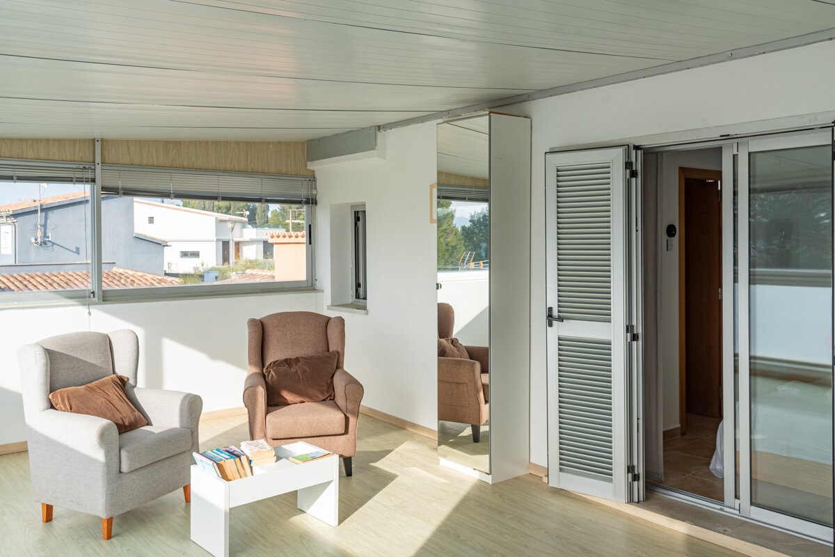A living room with two chairs and a table with books on it