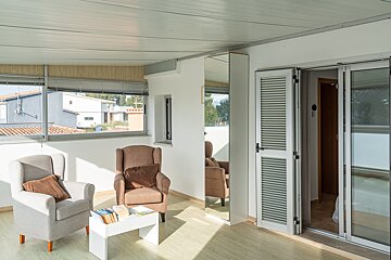 A living room with two chairs and a table with books on it