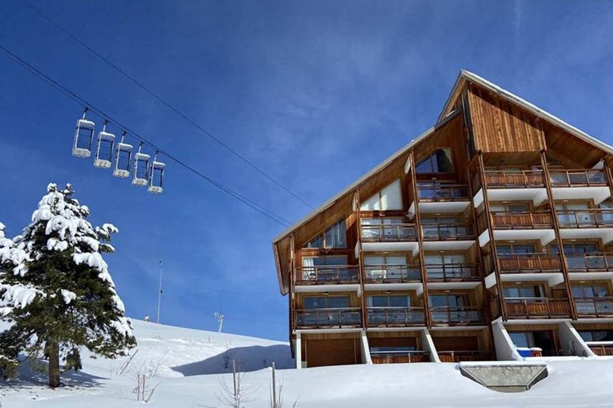 A ski lift is going up to the top of a snowy mountain