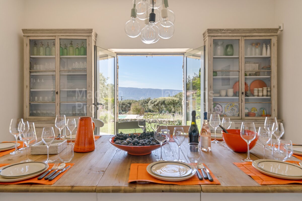A dining room table with a bowl of grapes on it