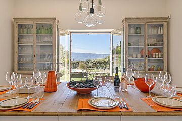 A dining room table with a bowl of grapes on it