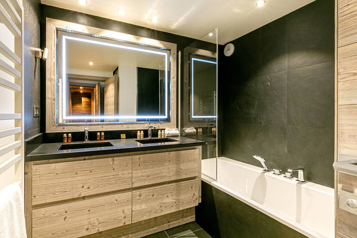 A bathroom with two sinks and a large mirror