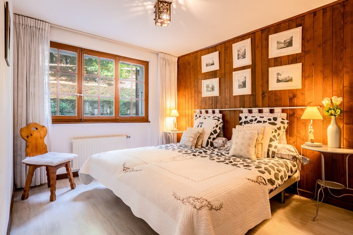 A bedroom with wood paneled walls and a bed