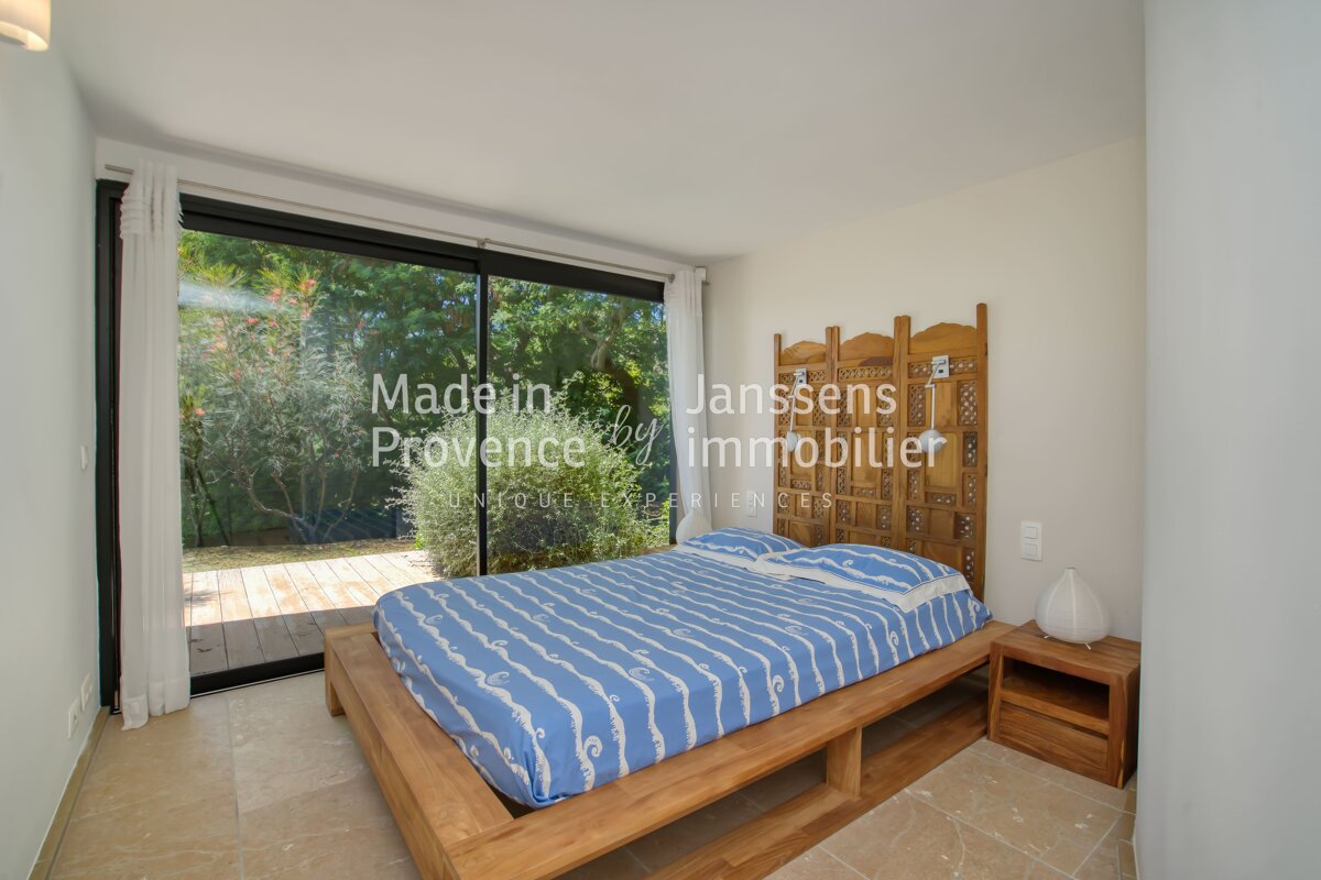 A bedroom with a bed and a screen that says made in janssens provence immobilier
