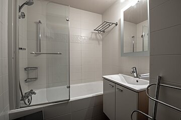 A bathroom with a bathtub a sink and a mirror