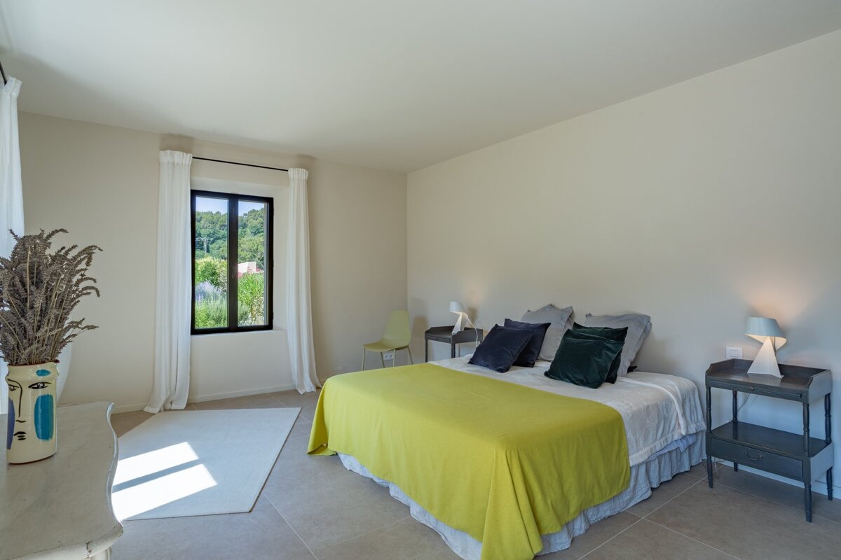 A bedroom with a bed and a vase with a face on it