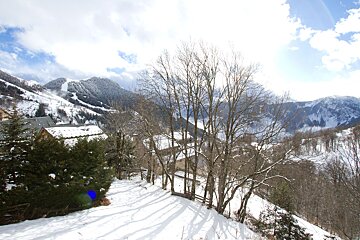 A snowy landscape with trees and mountains in the background