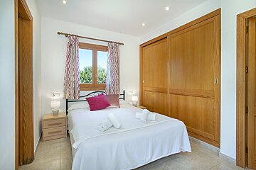 A bedroom with a large bed and a window
