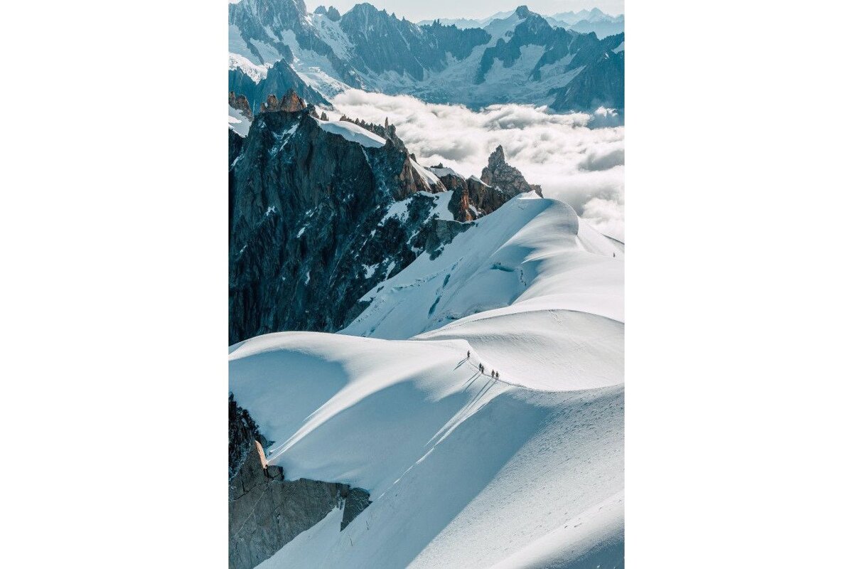 A group of people walking up a snow covered mountain