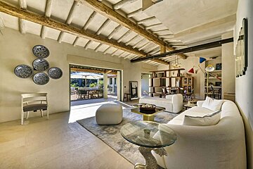 A living room with a white couch and a glass table