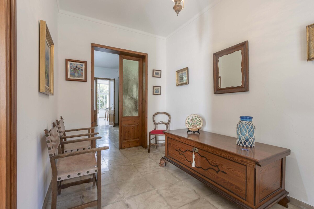 A hallway with a wooden chest and chairs