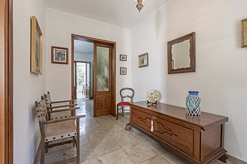A hallway with a wooden chest and chairs