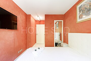 A bedroom with red walls and the word home on the wall