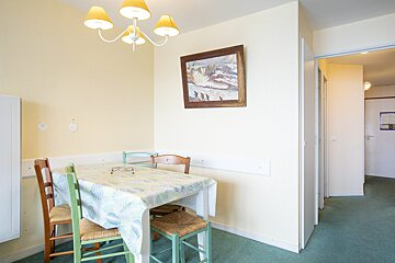 A room with a table and chairs and a picture on the wall