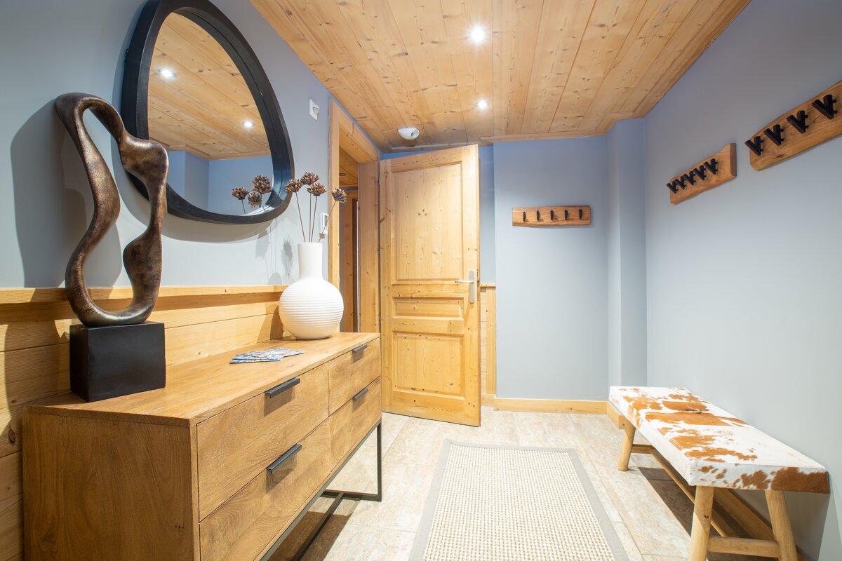 A hallway with a wooden dresser and a mirror