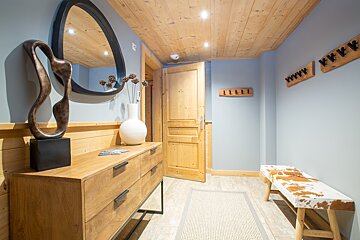 A hallway with a wooden dresser and a mirror