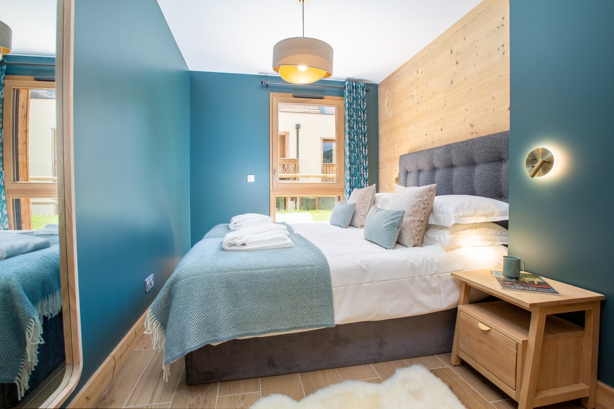 A bedroom with blue walls and a large bed
