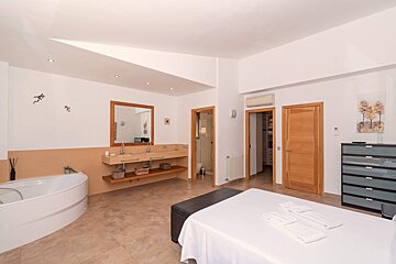 A bedroom with a bathtub and two sinks