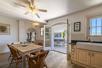A kitchen with a table and chairs and a ceiling fan