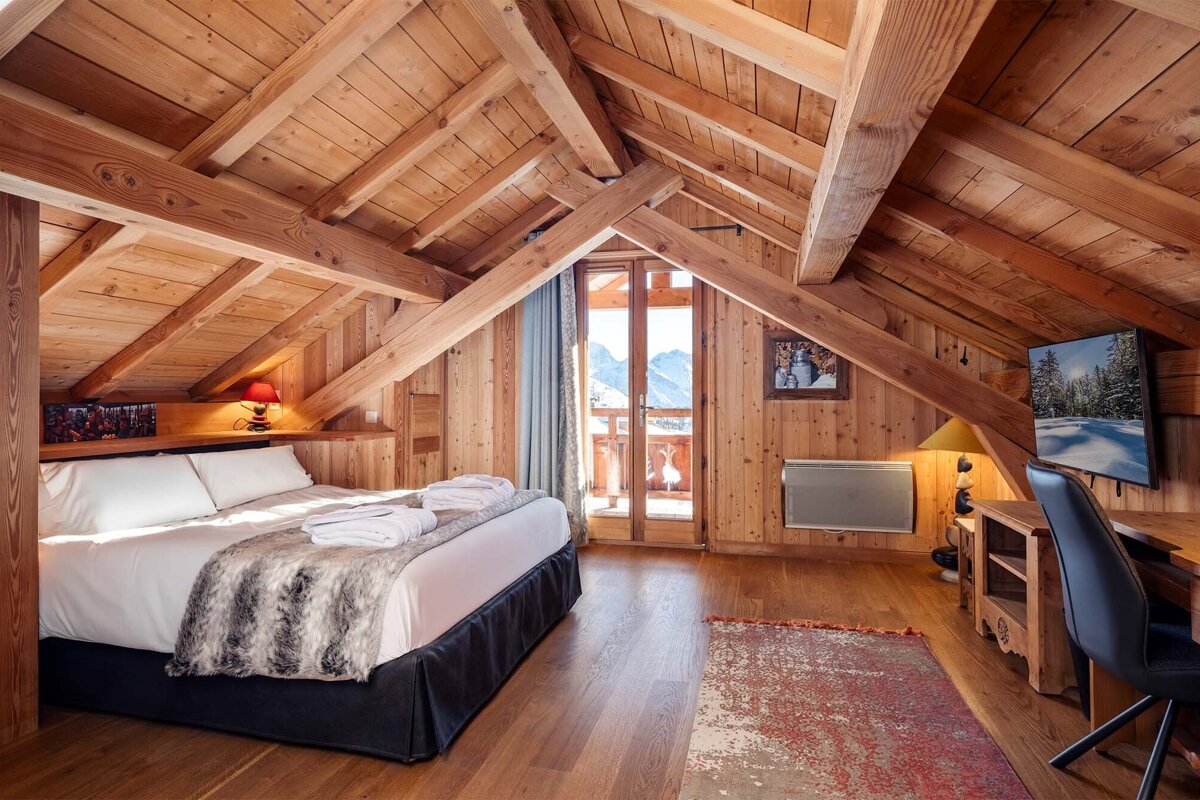 A bedroom with a large bed and a flat screen tv