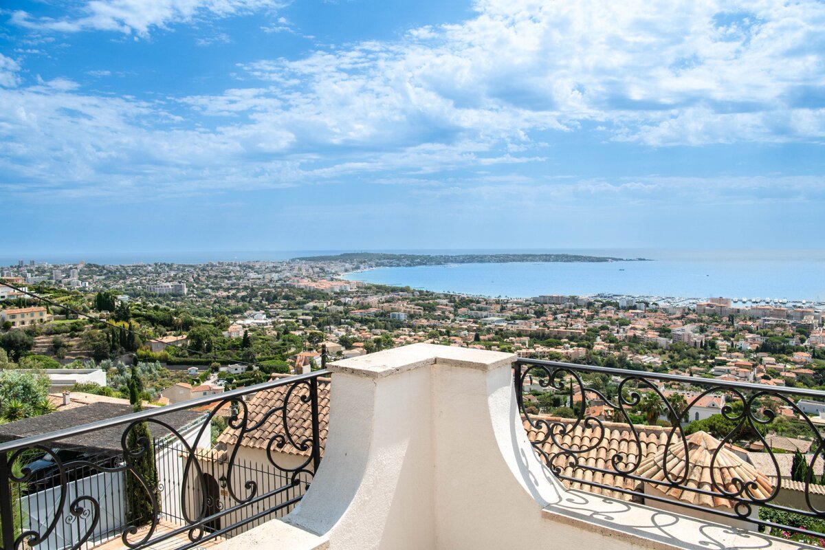A balcony with a view of a city and the ocean