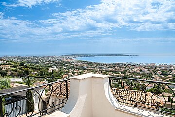 A balcony with a view of a city and the ocean