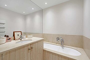 A bathroom with a bathtub and a sink with a picture of a woman on the counter