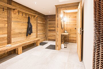 A hallway with wooden walls and a wooden bench