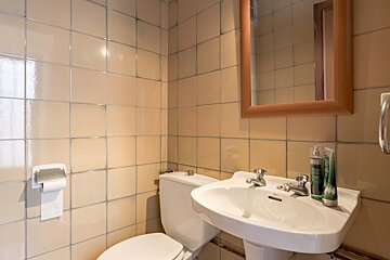 A bathroom with a toilet sink and a mirror